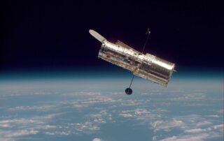 The Hubble Space Telescope hovers at the boundary of Earth and space in this picture, taken after Hubble's second servicing mission in 1997.